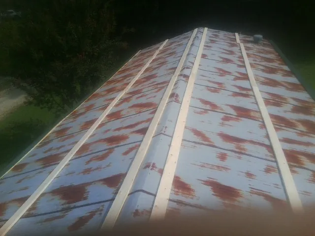 Rusted metal roof panels with new wood purlins before replacement — Storm Damage Roof Repair in Warner by Roofing Brothers